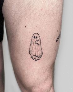 a man's leg with a ghost tattoo on the side of his thigh, which is black and white