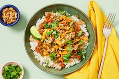 a plate with rice, meat and cilantro on it next to two bowls