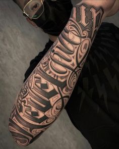 a man with a black and grey tattoo on his arm