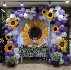 a sunflower themed birthday party with purple and white balloons, greenery and flowers