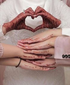 two brides holding their hands in the shape of a heart