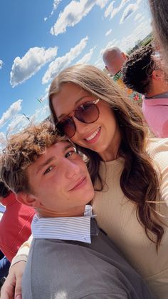 a man and woman taking a selfie in front of the camera on a sunny day