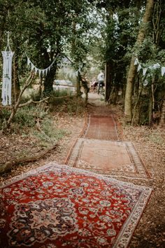 an old rug is laying on the ground in front of some trees and bunting