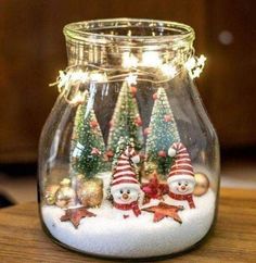 a glass jar filled with snowman and christmas trees