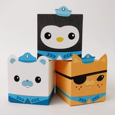 three small boxes with animals on them sitting next to each other in front of a white background