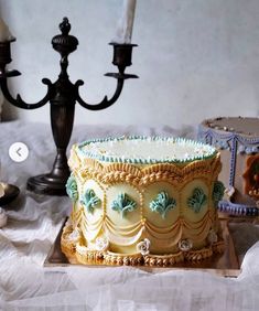 a cake sitting on top of a table next to two candelabra candles