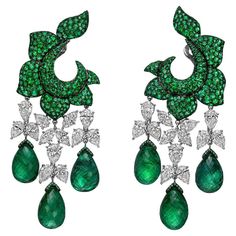 De Grisogono chandelier earrings handmade in 18k white gold and blackened 18k gold, each featuring a floral motif surmount pavé-set with emeralds suspending three drops composed of a chain of pear and marquise-shaped diamonds ending in larger briolette-cut emeralds. Twenty-six diamonds weighing approximately 15.12 total carats. Six briolette-cut emerald drops weighing approximately 63.78 total carats. 652 round-cut emeralds weighing approximately 71.70 total carats. Signed "de Grisogono" and num Grisogono Jewelry, Diamond Chandelier Earrings, Diamond Chandelier, Flower Leaf, Emerald Earrings, Green Flower, I Love Jewelry, Emerald Jewelry, Diamond Drops