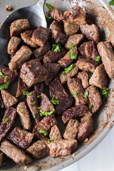 a pan filled with meat and garnished with parsley