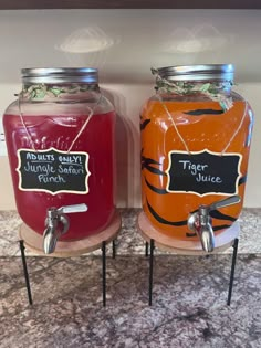 two jars filled with liquid sitting on top of a counter