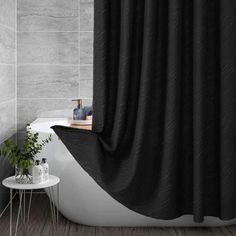 a black shower curtain in a bathroom next to a bathtub