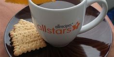 a cup of tea and crackers on a saucer with orange wedges in it