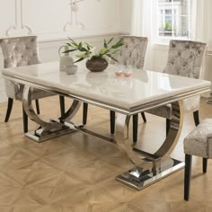 a dining room table with chairs and a vase on the end shelf next to it