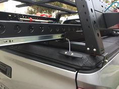 the back end of a silver truck with its cargo compartment open and some wires attached to it