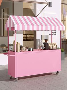 a pink ice cream cart sitting in front of a building