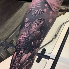 a man with a tattoo on his arm that has a turtle and fish in it