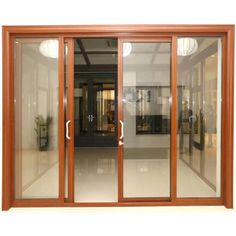 an open glass sliding door in front of a building with potted plants on the outside