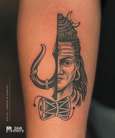 a tattoo with a woman's face and an arrow on her thigh, in black ink