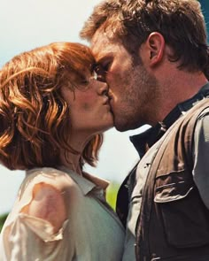 a man and woman kissing each other while standing next to each other