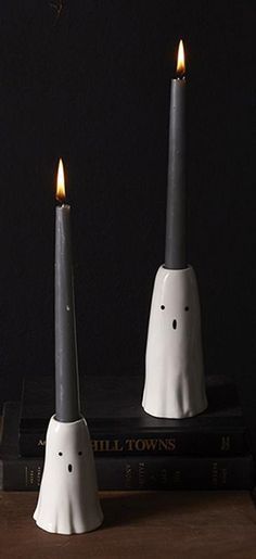 two candles sitting on top of books next to each other