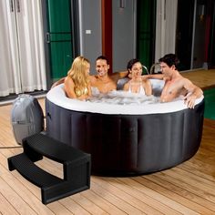 a group of people sitting in a large hot tub next to a water heater