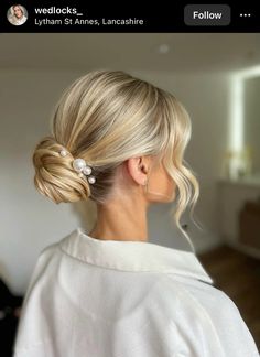 a woman with blonde hair in a low bun