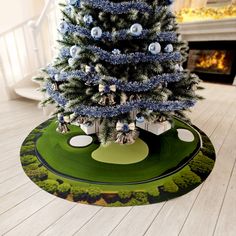 a christmas tree with ornaments on it in the middle of a living room floor mat