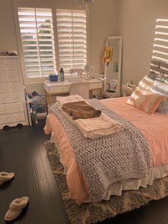 a bedroom with a bed, dresser and shoes on the floor in front of it