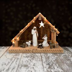 a nativity scene with figurines and lights in the shape of a house