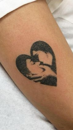 a woman's arm with a black and white photo of a person holding a baby