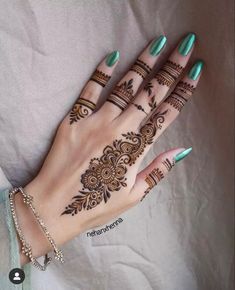 a woman's hand with henna tattoos on it