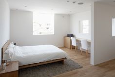 a bedroom with white walls and wooden floors