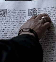 a person holding onto a piece of paper with writing on it and two rings in their hand