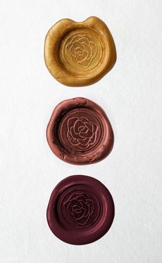 three wax seals sitting on top of each other in front of a white background,