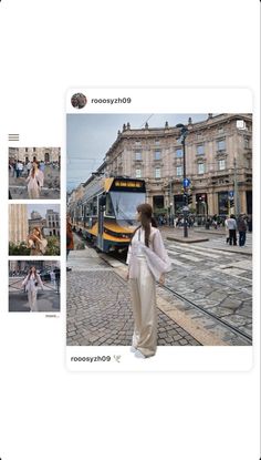 a woman standing on the side of a road next to a train and some buildings