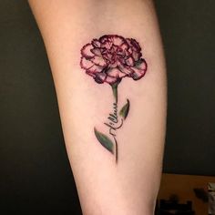 a flower tattoo on the right thigh with a small hand holding it up to its side