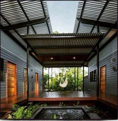 an outdoor room with a hammock in the center and water feature on the floor