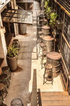 an alleyway with lots of metal buckets and tables