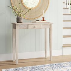 a wooden table with a vase on top of it and a mirror above the table