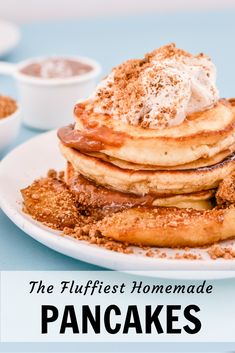 pancakes with powdered sugar and whipped cream on top, sitting on a white plate