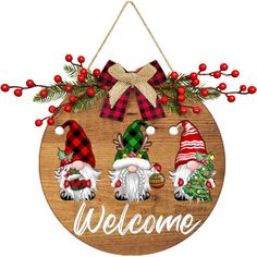 a wooden sign with gnomes and christmas decorations hanging from it's front door