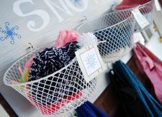 two baskets filled with clothes hanging on a wall next to a sign that says snow