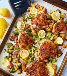 chicken, broccoli and lemons on a baking sheet