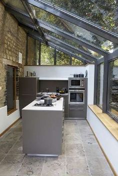 a kitchen with an oven, stove and sink in it's center island next to a window