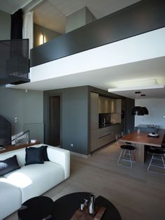 a living room filled with furniture next to a kitchen and dining room table on top of a hard wood floor