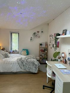 a bedroom with a bed, desk and shelves on either side of the room is lit up by blue lights