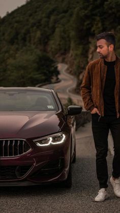 a man standing next to a brown car