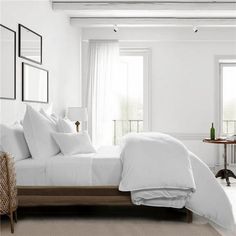 a bed with white sheets and pillows in a room next to two pictures on the wall