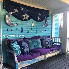 the porch is decorated with blue and purple pillows, stars and crescents on the wall