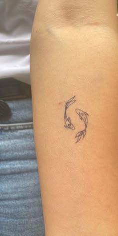 a woman with a tattoo on her arm that has two koi fish in it