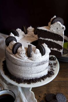 a cake with oreo cookies and cream frosting on it sitting on a plate